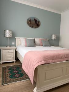 a bedroom with a bed with a pink blanket and two lamps at Coresi Long Stay Apartment in Braşov