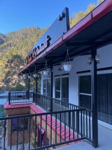 a building with a balcony with a sign on it at NIWALA Hotel & Restaurant , Kainchi Dham in Rāmgarh