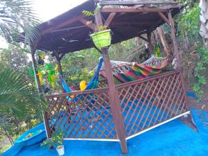 a wooden pergola with a hammock under it at Palais du Charme Roy in Saint-Claude