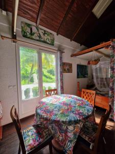 a table and chairs in a room with a window at Palais du Charme Roy in Saint-Claude +2 photos