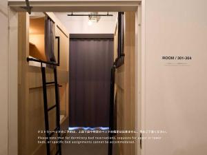 a mirror in a room with a curtain at Hotel Plus Hostel TOKYO ASAKUSA 1 in Tokyo