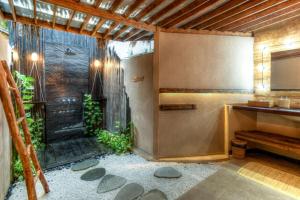 a bathroom with a shower with rocks in it at Hammerhead Villa, SHOTI Gili in Gili Trawangan