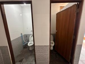 een badkamer met 2 toiletten en een houten deur bij Honey moon party in Ban Khlong Mae Nam +14 foto's