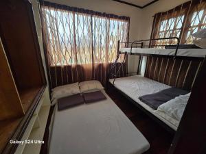 バギオにあるHillside Vacationers homestayの二段ベッドが2つと窓のある部屋