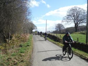 a group of people riding bikes down a road at Fairburn Activity Centre in Contin