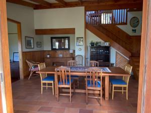 a dining room with a wooden table and chairs at Above the Bay in Hahei