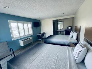 a hotel room with two beds and a window at Super 8 by Wyndham Bakersfield CA in Bakersfield