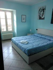 um quarto com uma cama numa parede azul em Appartamento De Angeli em Laveno-Mombello