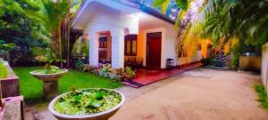 a house with a courtyard with plants in the yard at Ayuvilla in Goiyapana