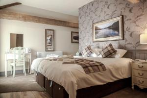 a bedroom with a large bed and a table at Crofters Lodge in Barrow in Furness