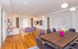a dining room with a wooden table and purple chairs at Dubrovnik Luxury Residence – L’Orangerie in Dubrovnik