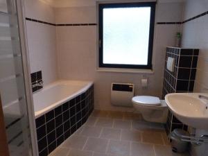 een badkamer met een bad, een toilet en een wastafel bij House of Rootz in Frankenau