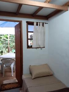 a room with a window and a chair and a table at Casa condomínio paz in Petrópolis