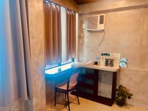 a bathroom with a blue sink and a chair at Pantropiko Lodge in El Nido