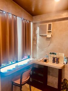 a small room with a table and a window with a fan at Pantropiko Lodge in El Nido +70 photos