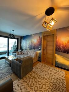 a living room with a couch and a table and a painting at Natural White apartments in Bjelašnica