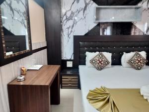 a bedroom with a large bed and a desk at Hotel Nagaon Point in Nowgong