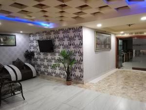 a room with a couch and a tv on a wall at Hotel Nagaon Point in Nowgong