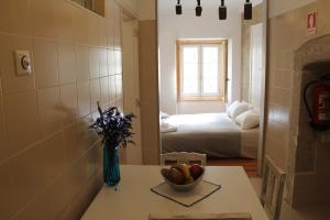 a room with a table with a bowl of fruit and a bedroom at Casa d Sintra in Sintra