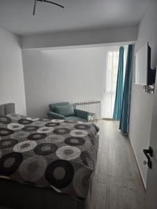 ein Schlafzimmer mit einem Bett und einer Couch und einem Fenster in der Unterkunft Family Apartament Mamaia in Mamaia Nord – Năvodari