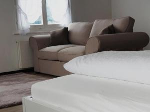 a living room with a brown couch and a window at Sternen Doppelzimmer in Benken