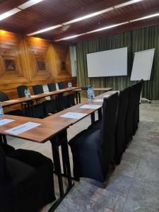 a conference room with long wooden tables and black chairs at Spichlerz na Krakowskiej in Kazimierz Dolny