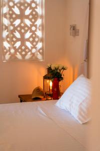 a bedroom with a bed with a pillow and a table at Mawimbi Cottage in Ukunda