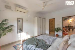 カンドリムにあるStayVista at The Zen Zone with Pool, BBQ, WiFiのベッドとリビングルームのある寝室