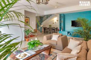 a living room with a couch and a table at StayVista at The Zen Zone with Pool, BBQ, WiFi in Candolim