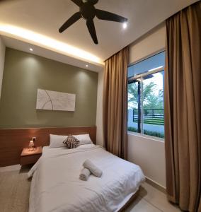 a bedroom with a bed with a ceiling fan and a window at Stillwater Retreat in Desaru in Kota Tinggi