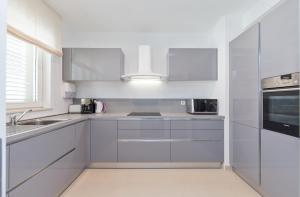 a white kitchen with white cabinets and a sink at Dubrovnik Luxury Residence – L’Orangerie in Dubrovnik