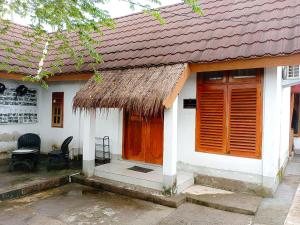 a small white house with a straw roof at Tania Homestay in Bumbang