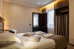 a bedroom with a large bed with pillows on it at MARION SPA Hotel in Bukovel