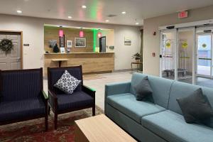 エルジンにあるCountry Inn & Suites by Radisson, Elgin, ILの青いソファと椅子2脚付きの待合室