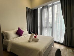 une chambre avec un lit blanc avec une fenêtre dans l'établissement Star Residence KLCC By FZB, à Kuala Lumpur