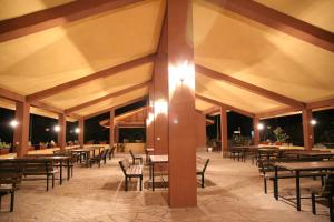 a covered patio with tables and chairs at night at Perperеshka River Villas in Stremtsi