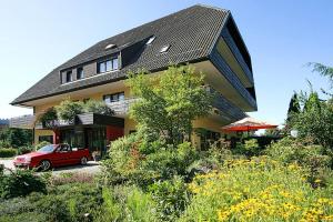 una macchina rossa parcheggiata di fronte a una casa di Hotel Sonne a Zell am Harmersbach