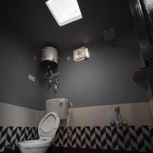 a bathroom with a white toilet in a room at Tattvammasi Stay in Bajaura