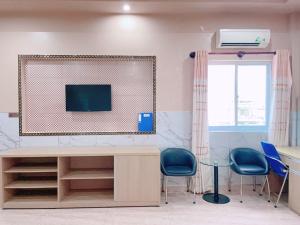 a room with a desk and chairs and a tv at Nam Kieu Hotel Ca Mau in Cà Mau
