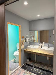 un bagno con due lavandini e un water di 公園一鹿背包客棧 Deer Park Hostel a Lukang