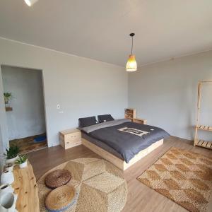 a bedroom with a bed and a table with two rugs at The Culture Home in Sa Pa