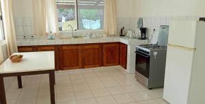 a kitchen with a refrigerator and a table in it at Town house beach 1 in Fare