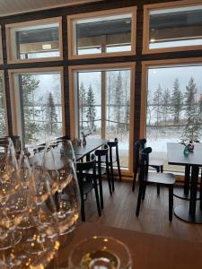 a dining room with tables and chairs and windows at Miilu Resort in Ylläsjärvi +74 photos
