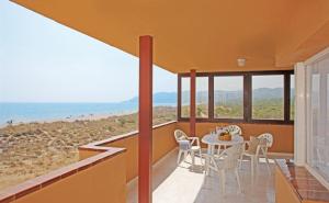 a dining room with a table and chairs and the beach at Apartaments Beach & Golf Resort in Pals