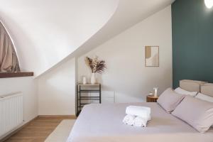 a bedroom with a white bed with towels on it at THE CORE - 4 min Walk to Bernina Express in Tirano