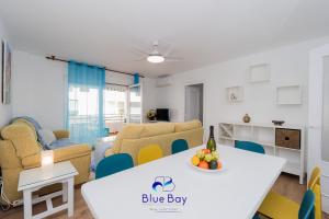 Una sala de estar con una mesa y sillas blancas. en At The Plaza Central Beach Flat, en La Herradura