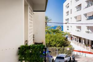 un coche aparcado delante de un edificio en At The Plaza Central Beach Flat, en La Herradura