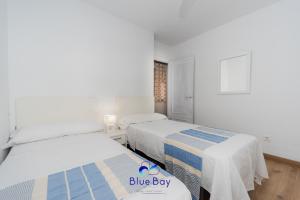 Un dormitorio con dos camas y un cartel de chico azul. en At The Plaza Central Beach Flat, en La Herradura