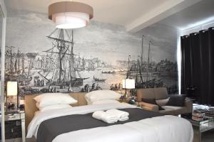 ディエップにあるVilla Castel Chambres d'hôtes B&Bの壁に絵が飾られた大きなベッドのある寝室
