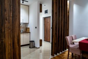 a kitchen with a table and a wooden door at Apartman ISKRA Vision in Arandelovac